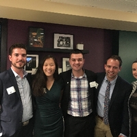 three men and two women arm in arm posing for a photo together